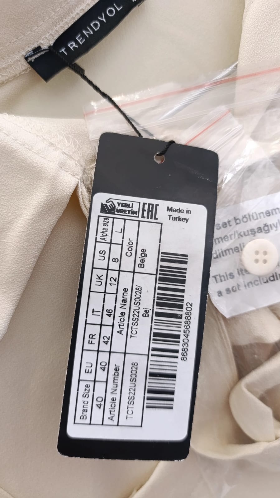 Trendyol price and size label on cream fabric, close-up