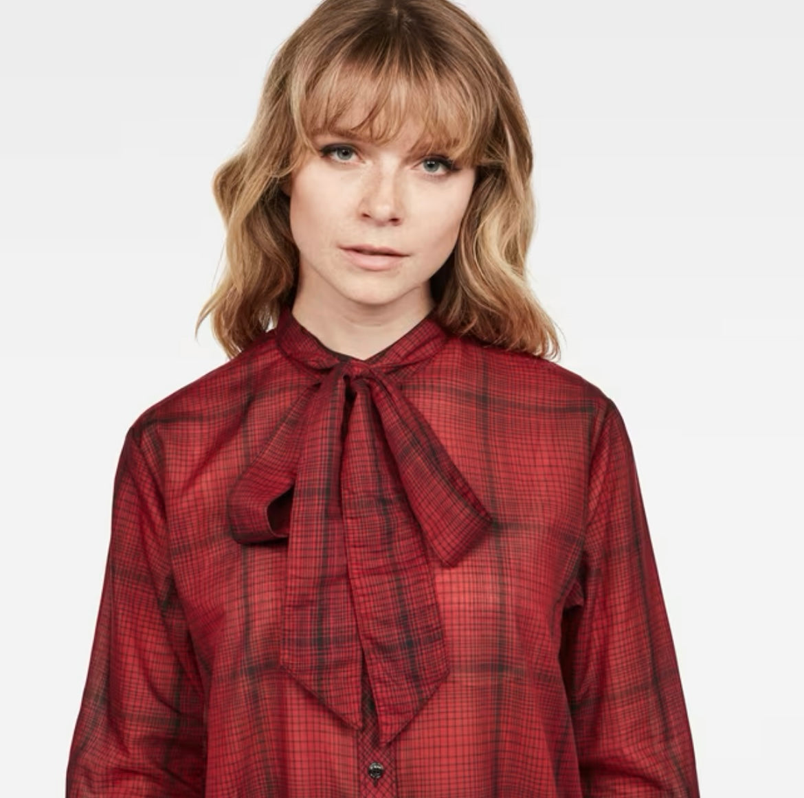 Close-up of tie bow neckline on red plaid G-Star Raw blouse worn by model