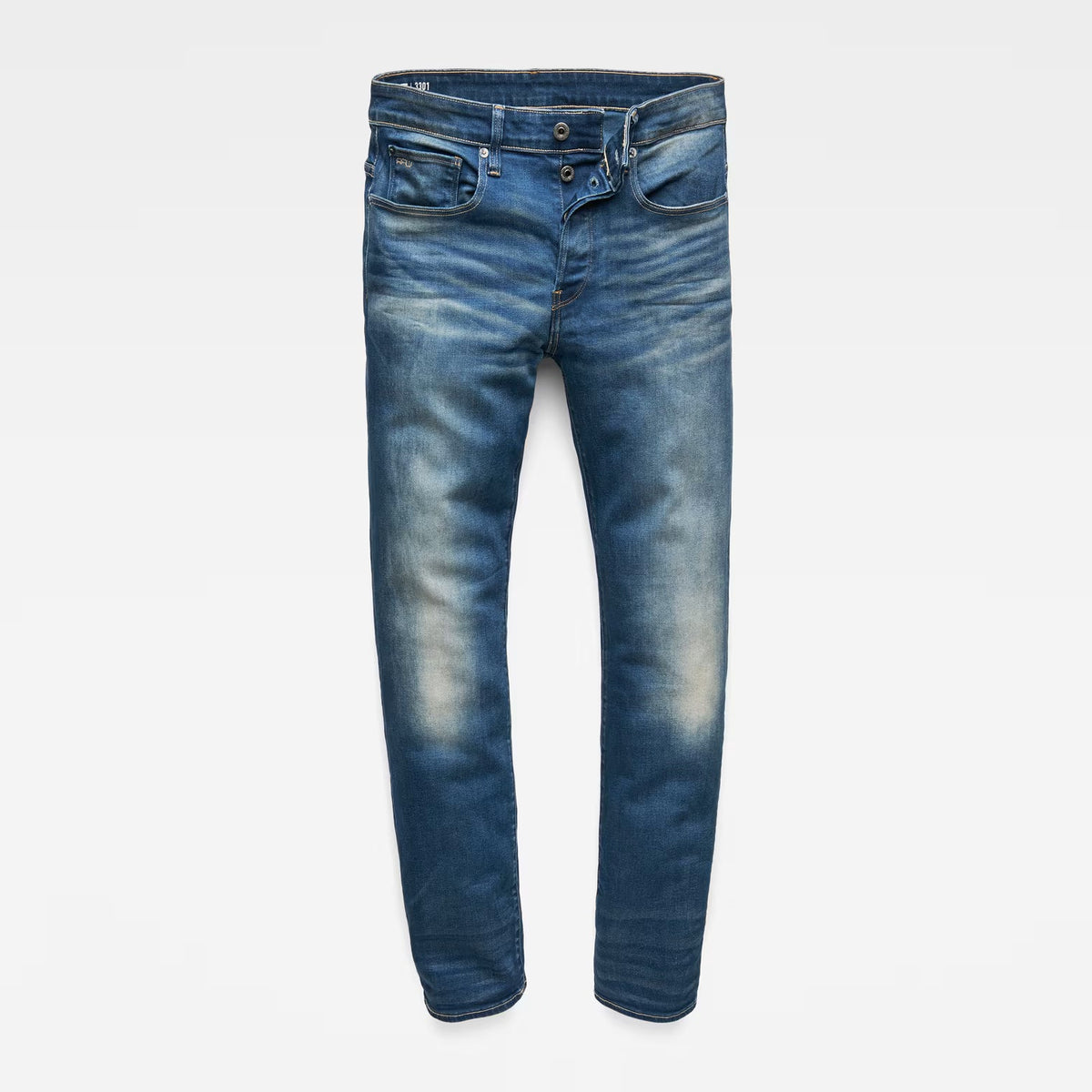 Detail close-up of medium blue jeans highlighting the back pocket and brand label on a white background.
