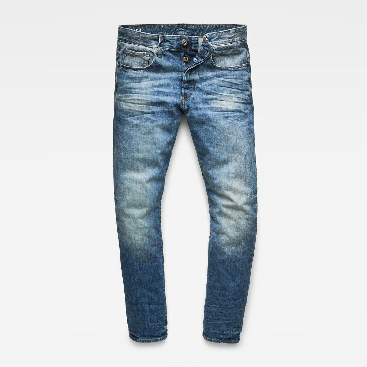Front view of medium blue jeans with a straight tapered fit and distressed details displayed on a white background.