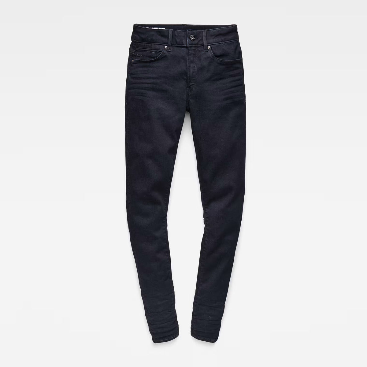 Flat lay of black skinny jeans with a high waist on a white background.