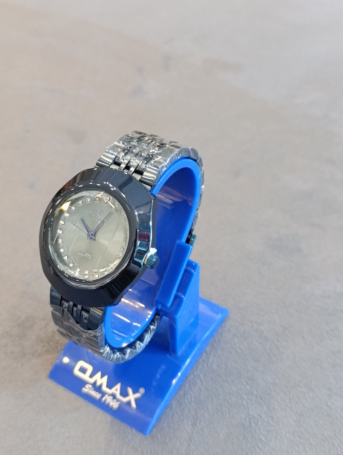 UNIQUE navy crystal bezel watch on blue display stand, angled view