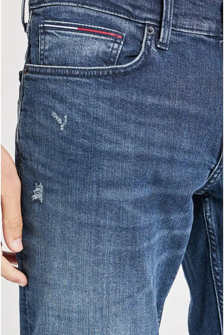 Close-up of Tommy Hilfiger mid wash jeans front pocket and distressing