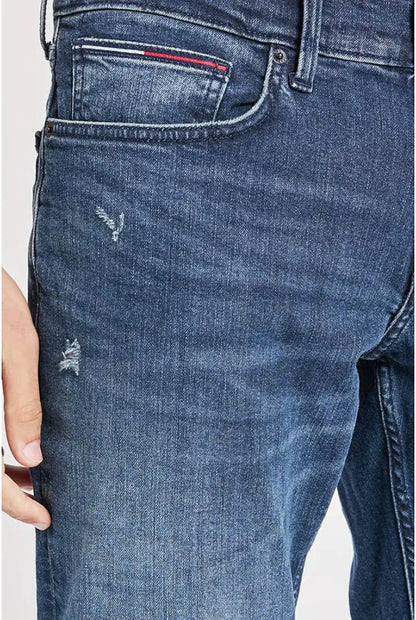 Close-up of Tommy Hilfiger mid wash jeans front pocket and distressing