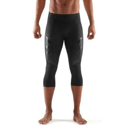 A male athlete wearing black Skins A400 3/4 compression tights, mid-stride during a workout.