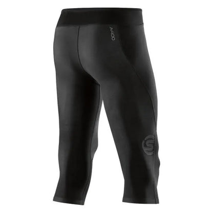 A male athlete wearing black Skins A400 3/4 compression tights, mid-stride during a workout.
