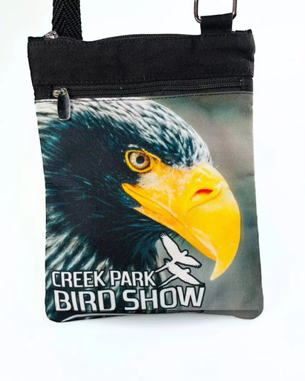 A stylish Creek Park Bird Show side bag with a black exterior and cloths straps. The bag has multiple compartments and pockets for storing essentials.