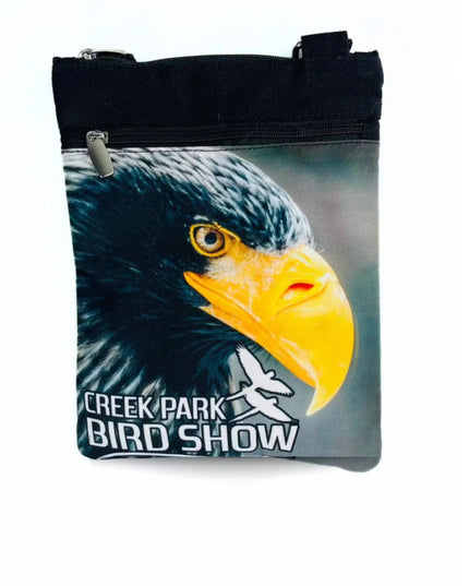 A stylish Creek Park Bird Show side bag with a black exterior and cloths straps. The bag has multiple compartments and pockets for storing essentials.