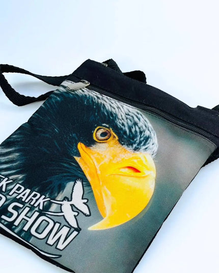 A stylish Creek Park Bird Show side bag with a black exterior and cloths straps. The bag has multiple compartments and pockets for storing essentials.