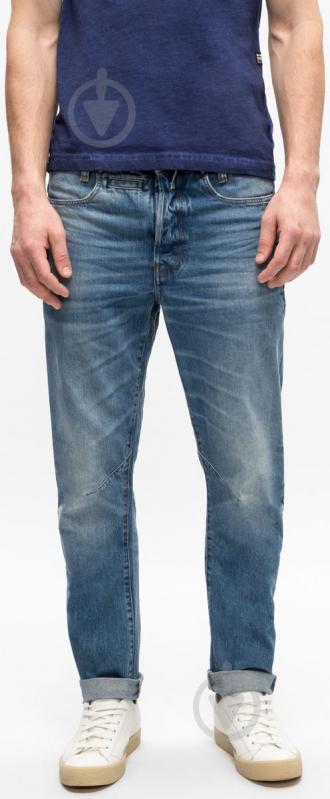 Front view of blue denim pants featuring a faded design and slim fit on a white background.