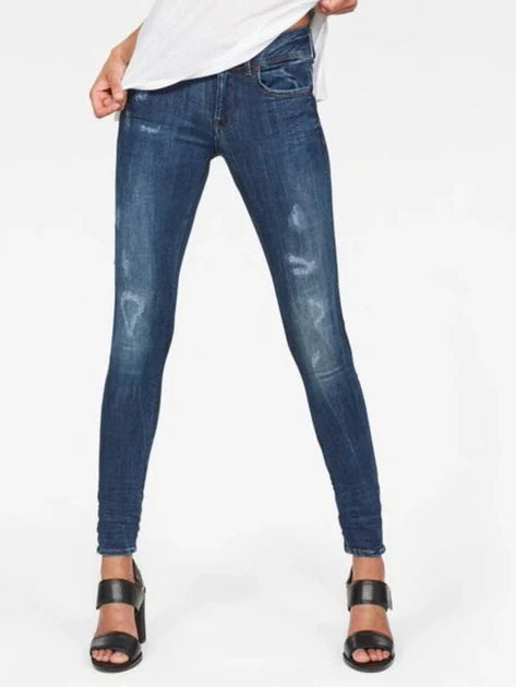 Front view of blue skinny jeans featuring distressed details on a white background