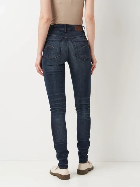 Back view of dark blue skinny fit jeans with a high waist on a white background