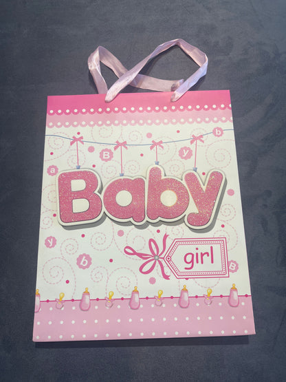 Baby girl pink gift bag with ribbon handles and Baby lettering, front view