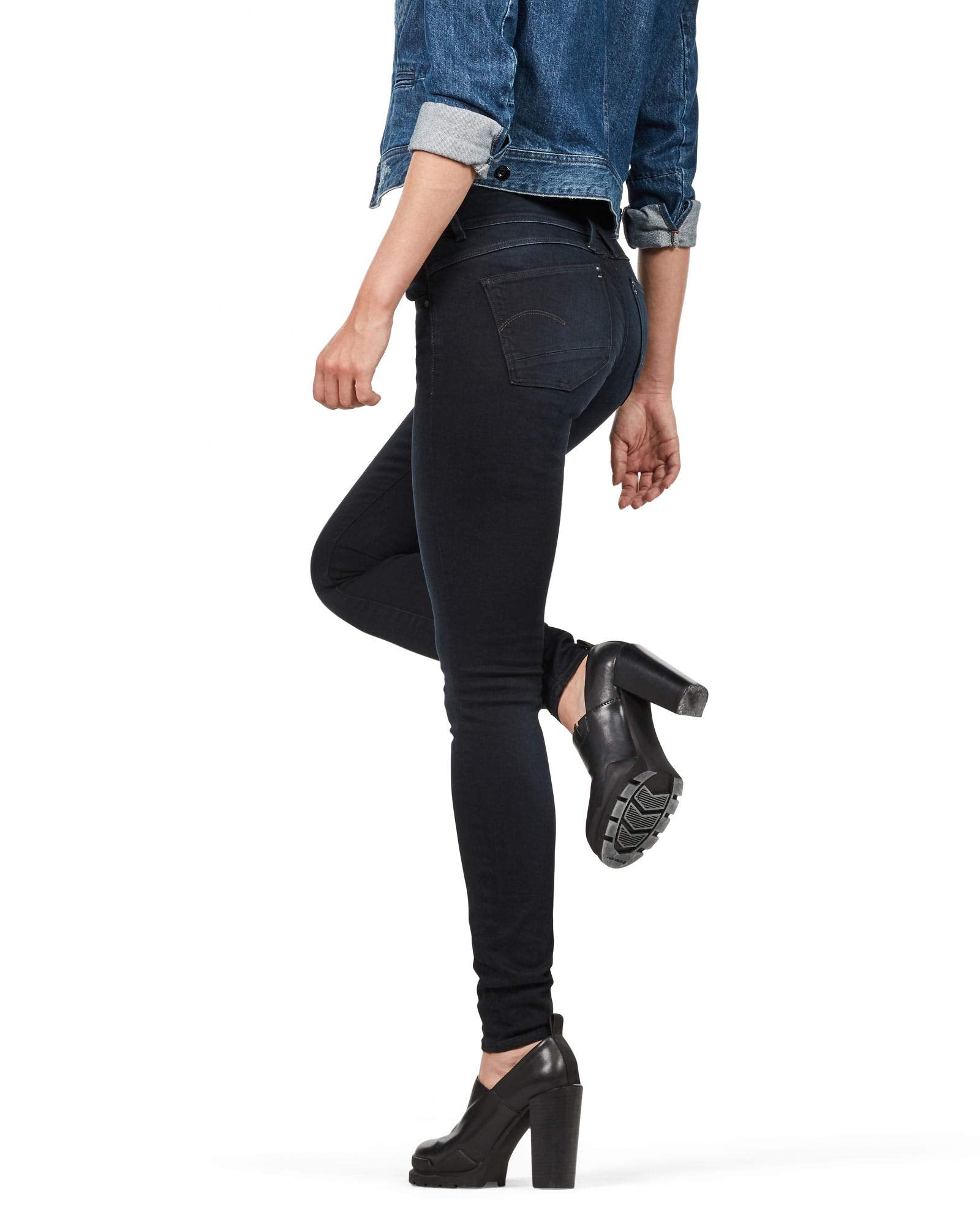 Side view of black skinny jeans featuring a slim fit and high waist in a studio setting.