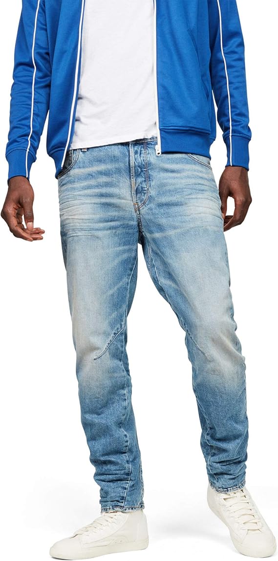 Front view of fitted blue jeans paired with a white t-shirt and sneakers against a white background.