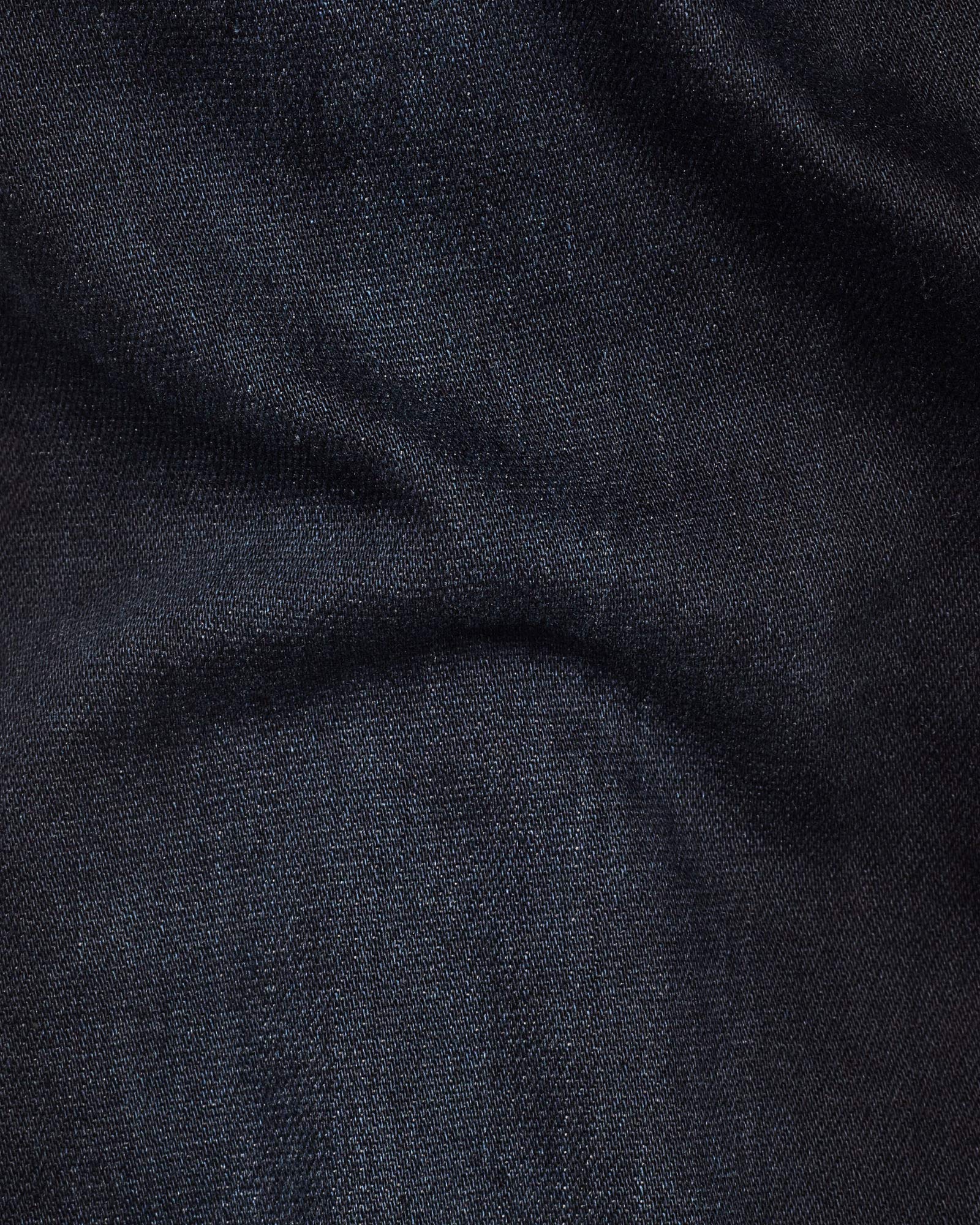 Close-up detail of dark blue denim fabric highlighting its soft texture and stretch features.