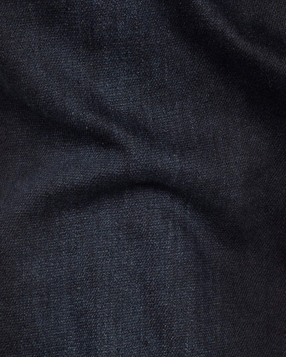 Close-up detail of dark blue denim fabric highlighting its soft texture and stretch features.