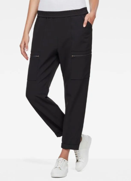 Woman in black G-Star Raw Hybrid boyfriend sport pants with white sneakers
