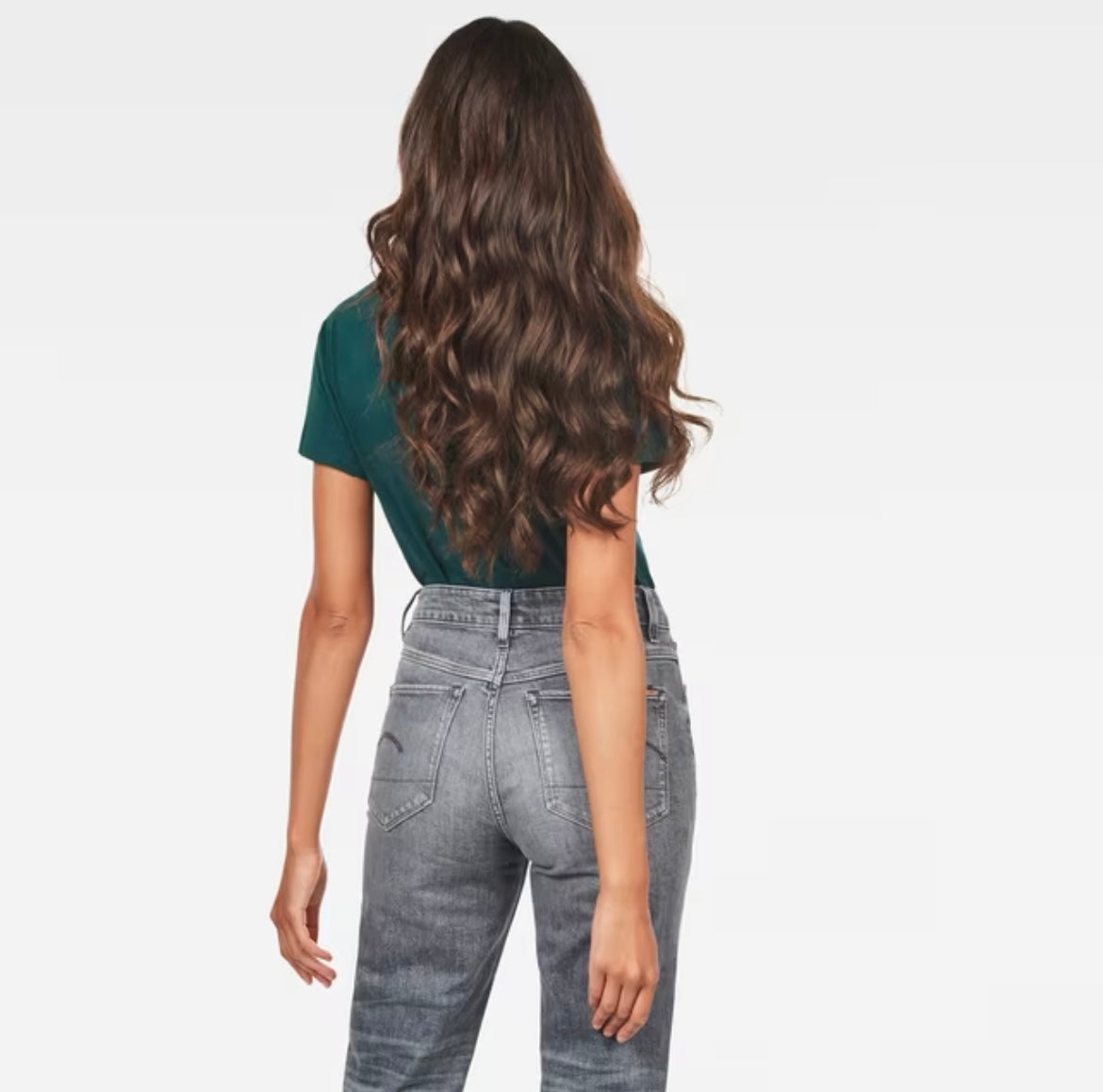 Back view of model with long hair in green G-Star Raw T-shirt and grey jeans