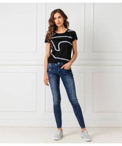 Woman in black G-Star Raw T-shirt with grey wavy line graphic and blue skinny jeans, full-length