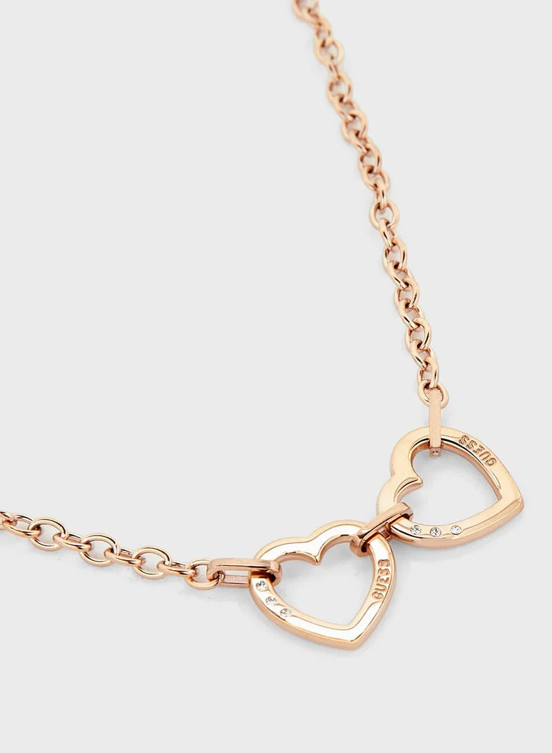 Close-up of rose gold double heart pendant on Guess chain necklace