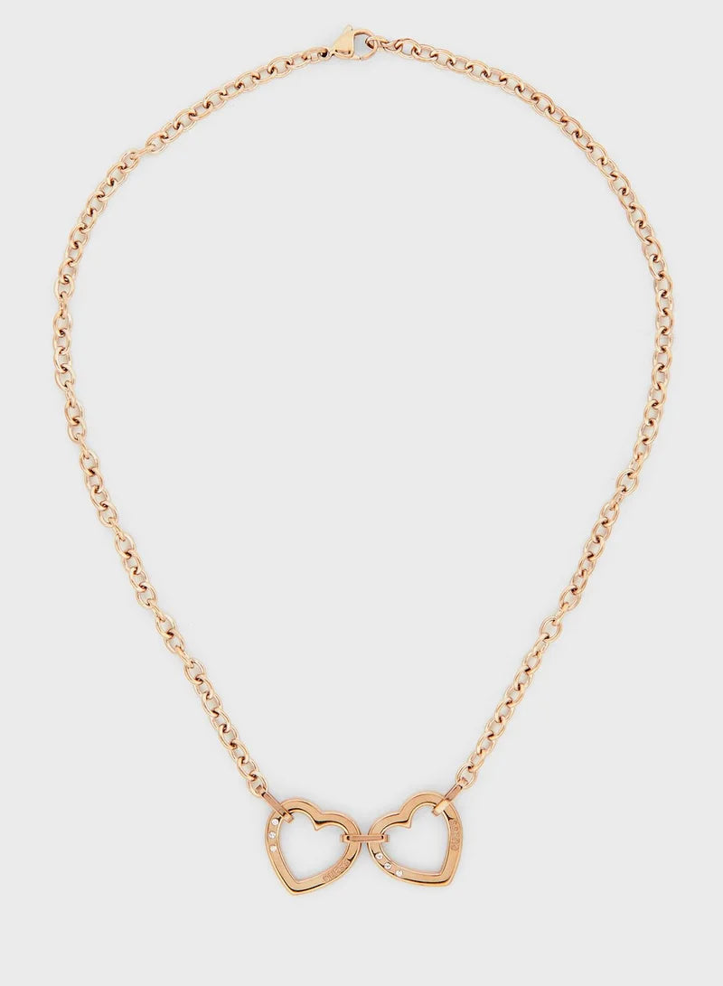 Guess rose gold necklace with linked hearts pendant laid in a loop