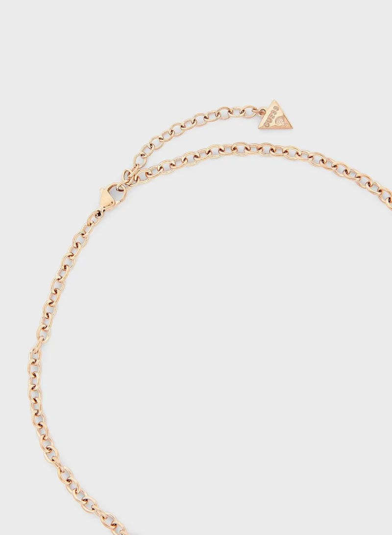Close-up of rose gold chain and triangle logo charm on Guess necklace clasp