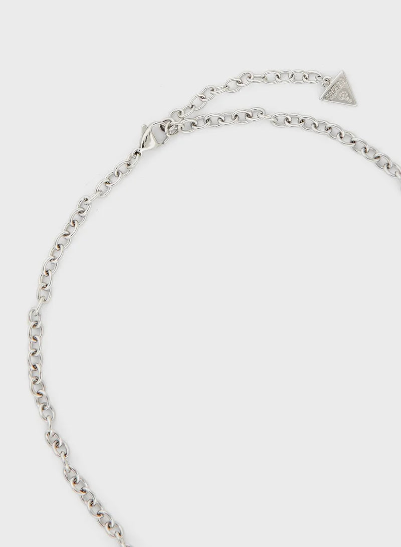 Close-up of silver chain and triangle logo charm on Guess necklace