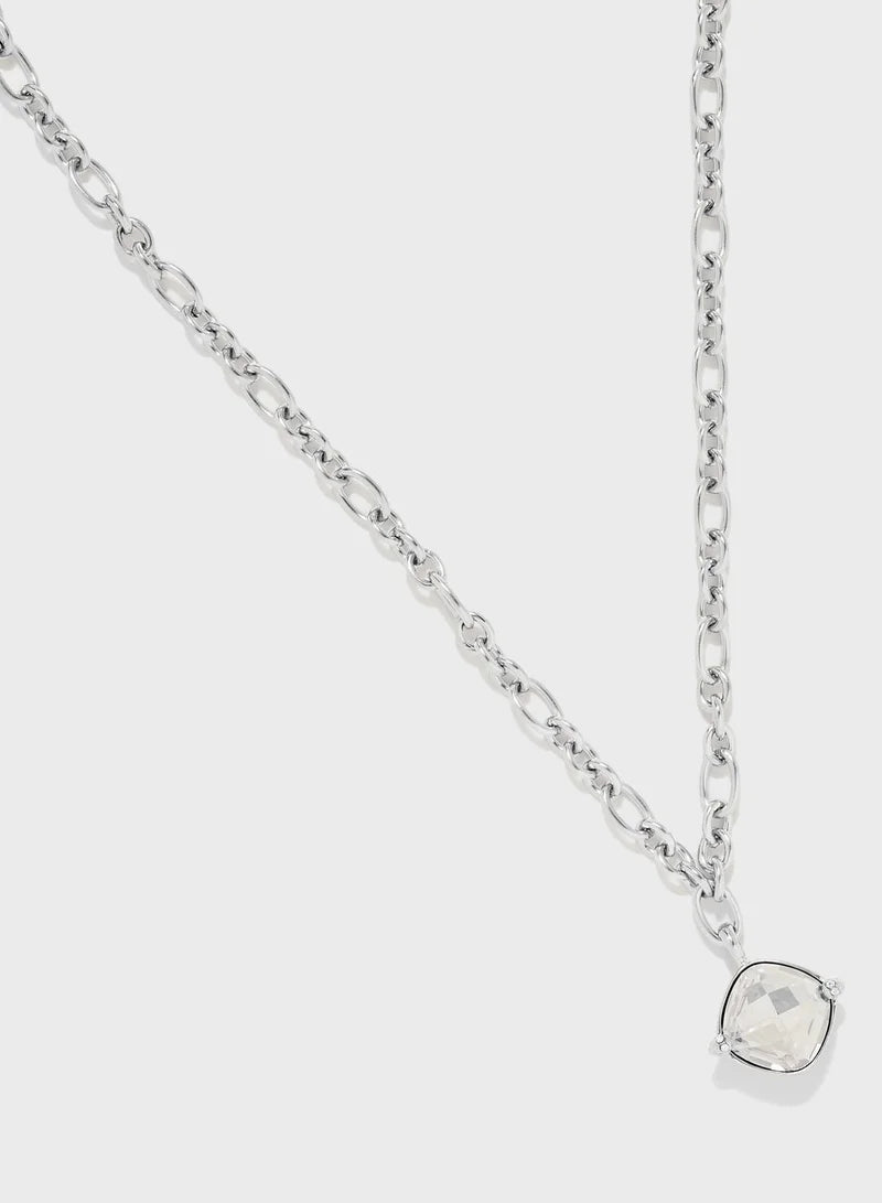 Close-up of square crystal stone pendant on silver Guess chain