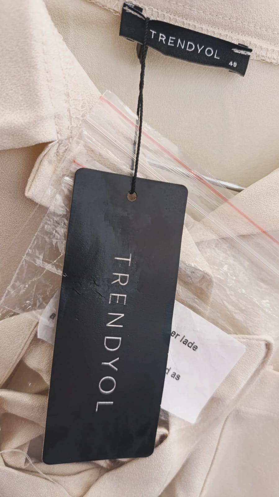 Trendyol hang tag on cream shirt, close-up