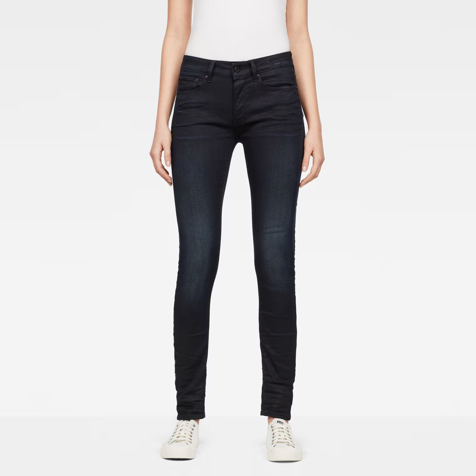 Front view of dark blue skinny jeans featuring a five-pocket design.