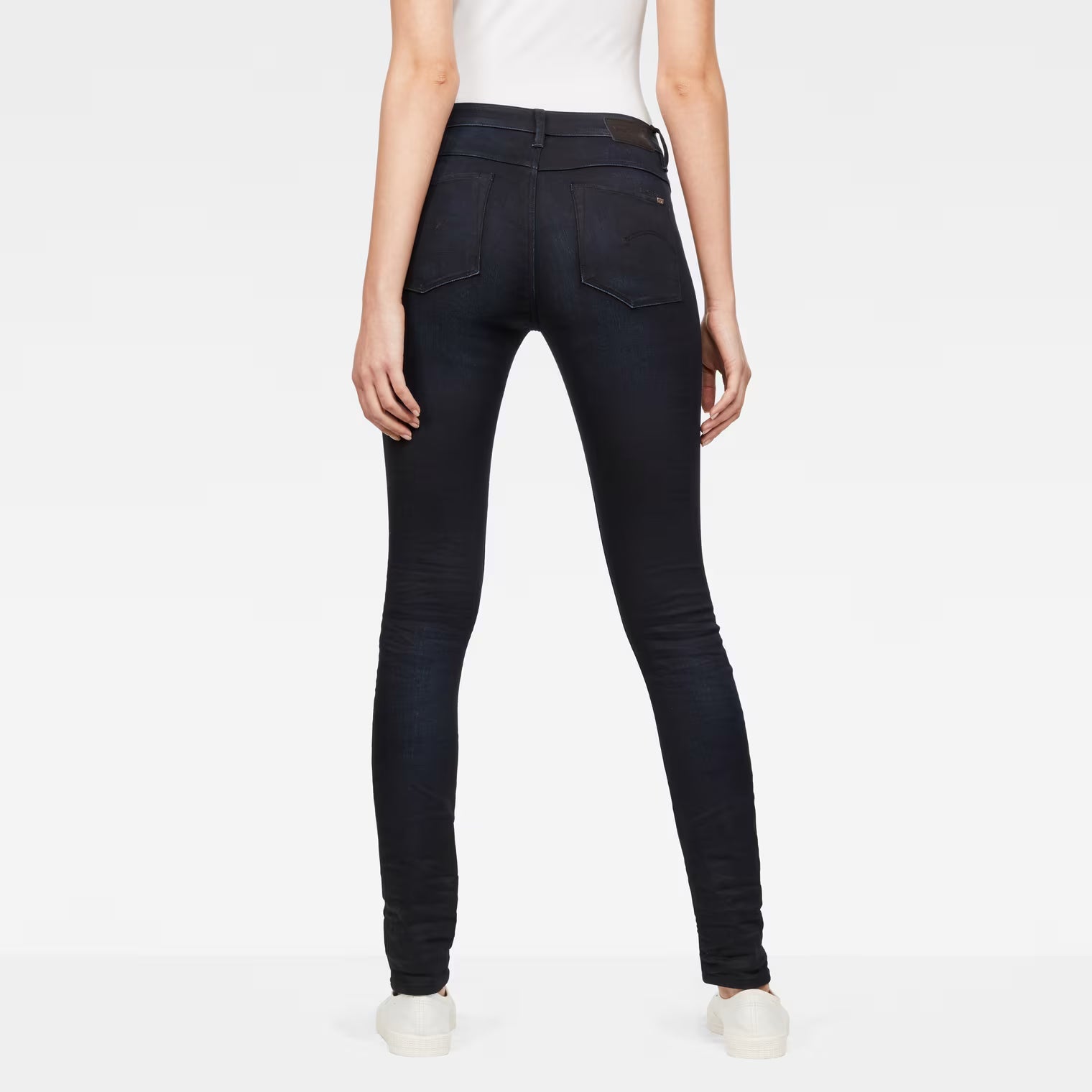 Back view of dark blue skinny jeans with a high waist design.