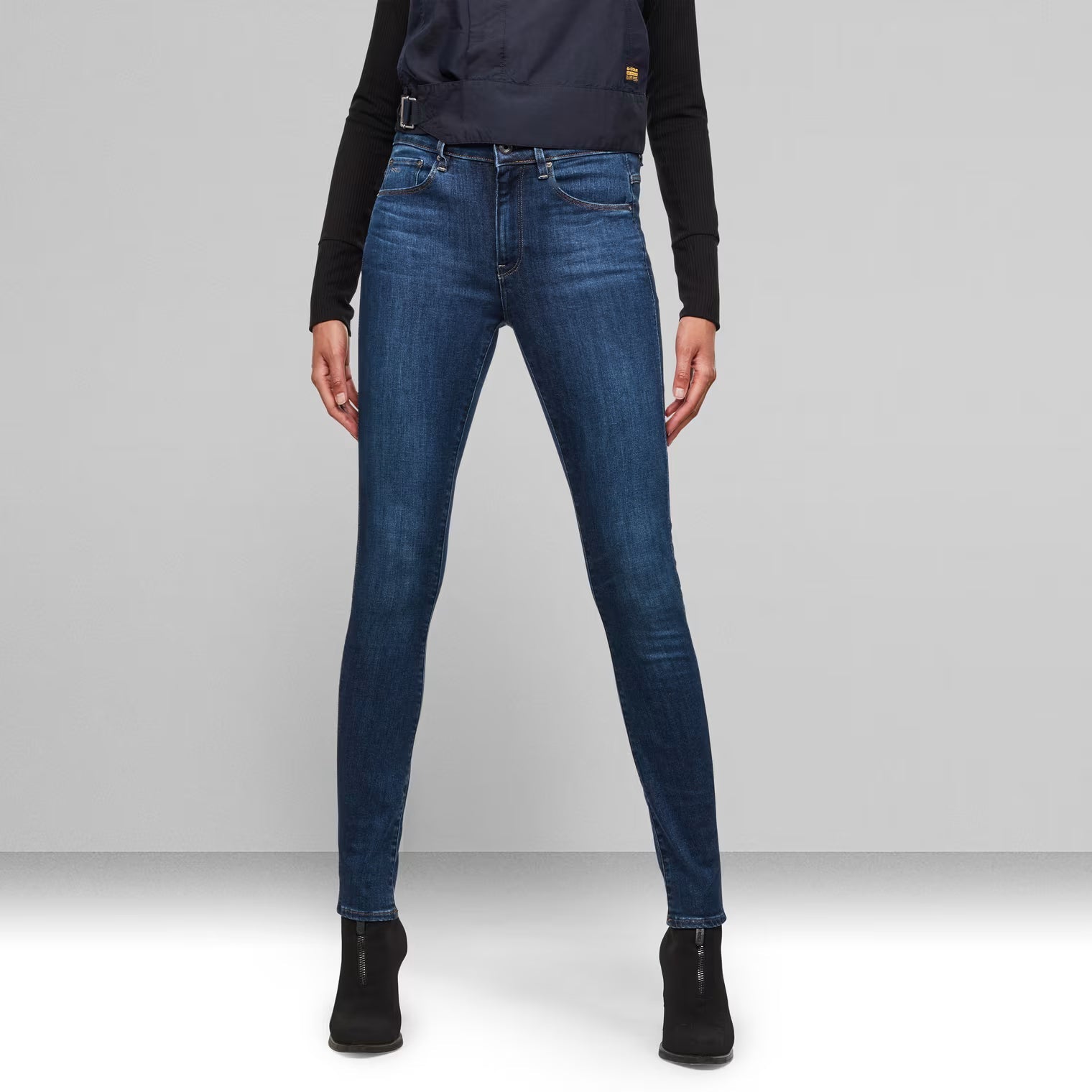 Front view of medium blue high waist skinny jeans showcasing the fit.