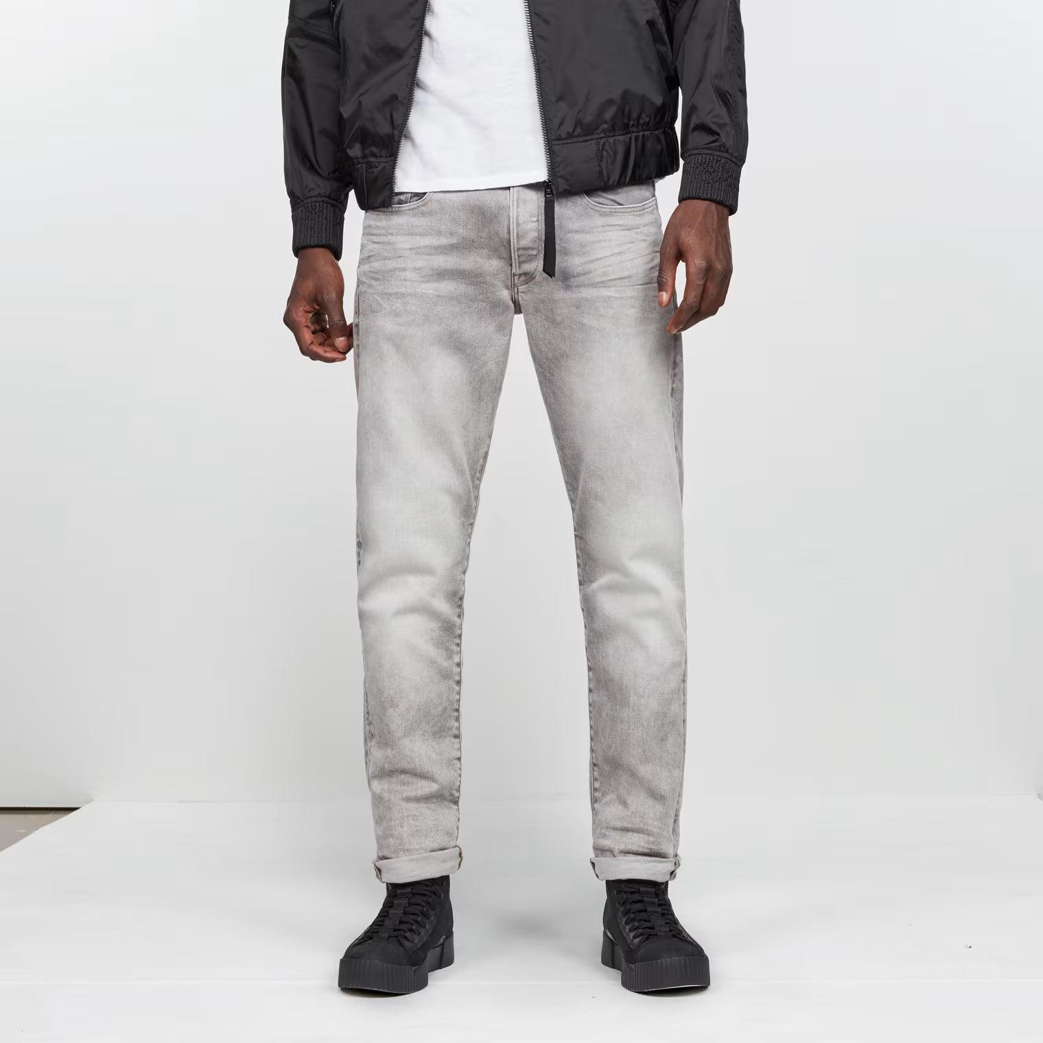 Front view of the grey tapered jeans featuring a regular fit and five pockets.