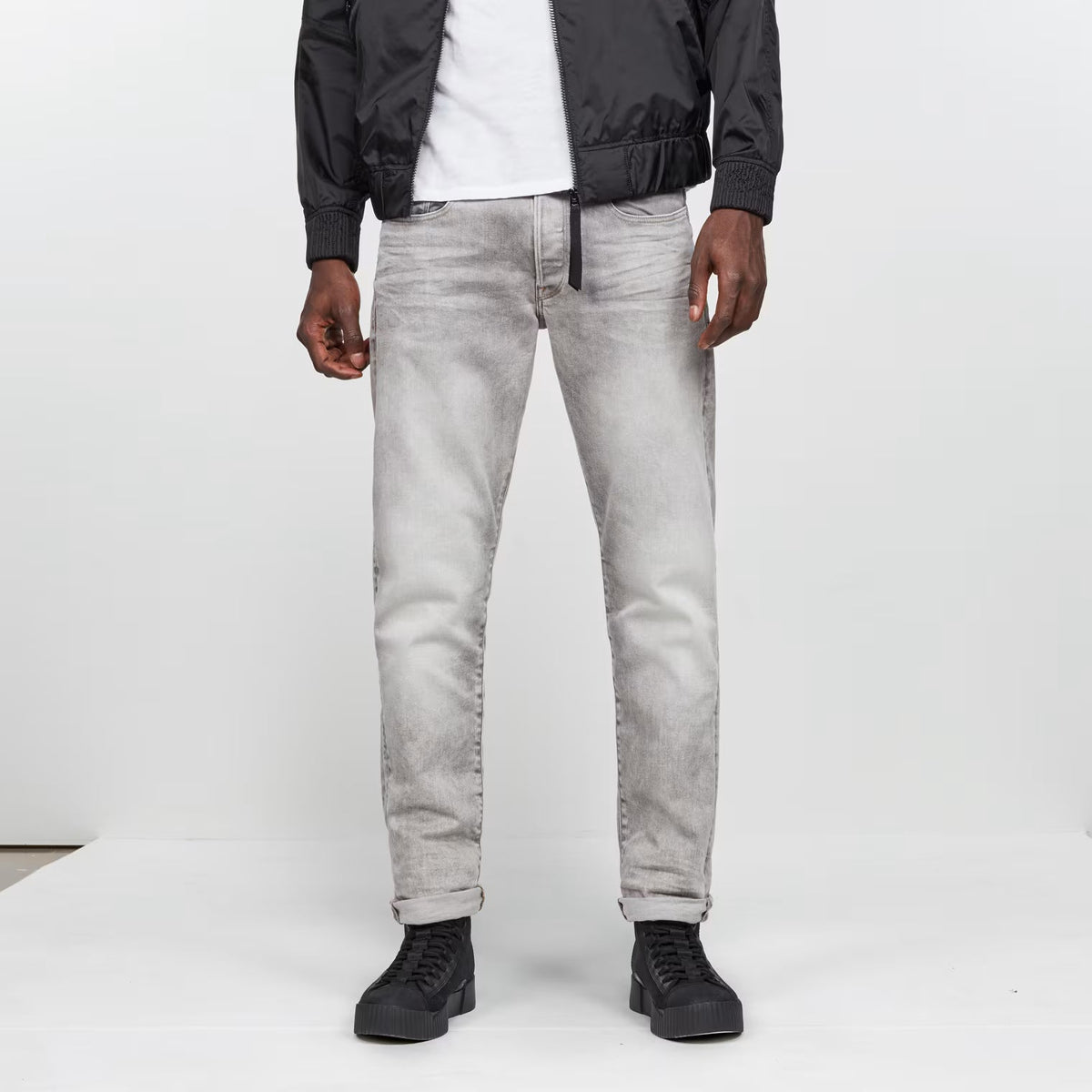 Front view of the grey tapered jeans featuring a regular fit and five pockets.
