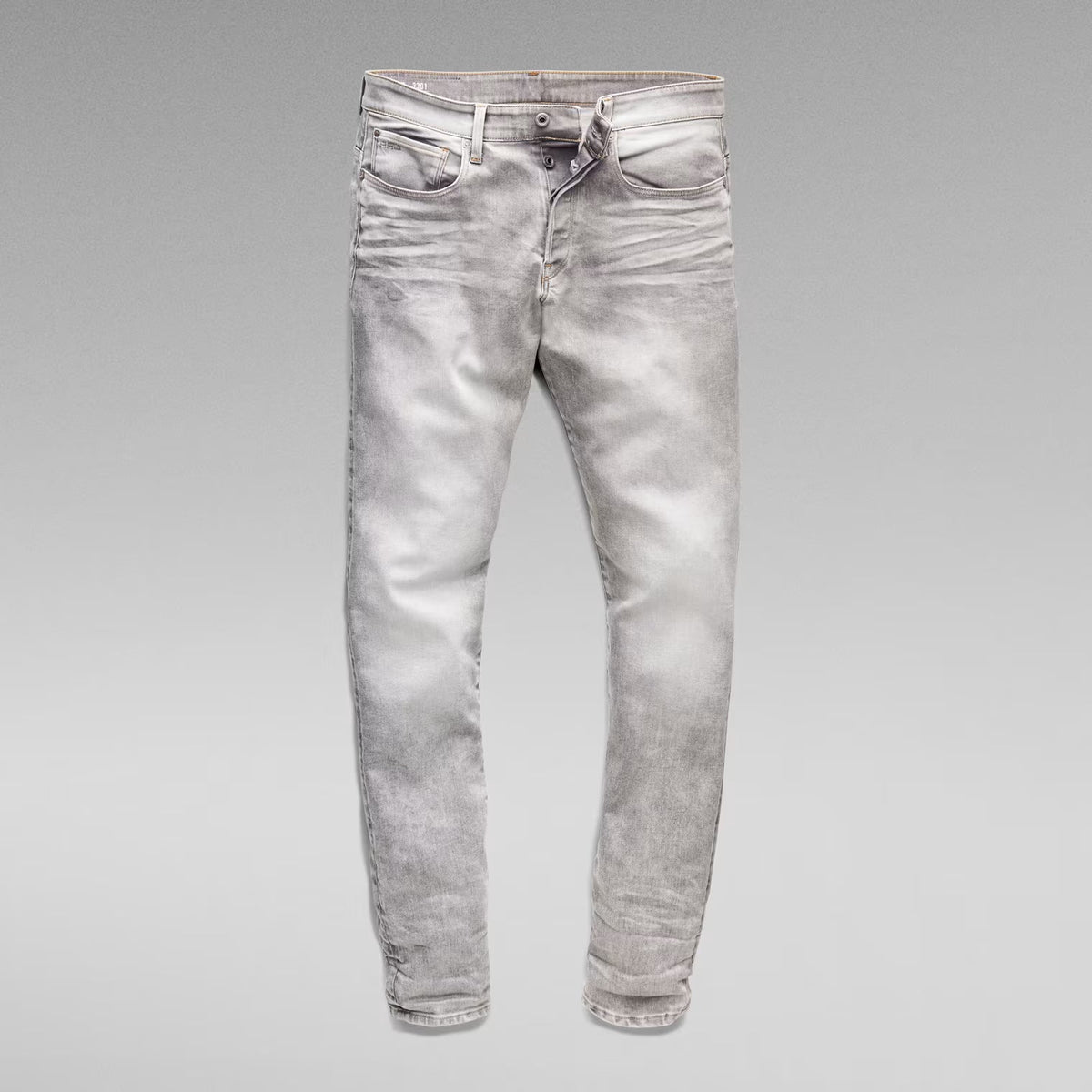 Unfolded front view of the grey tapered jeans on a solid background.