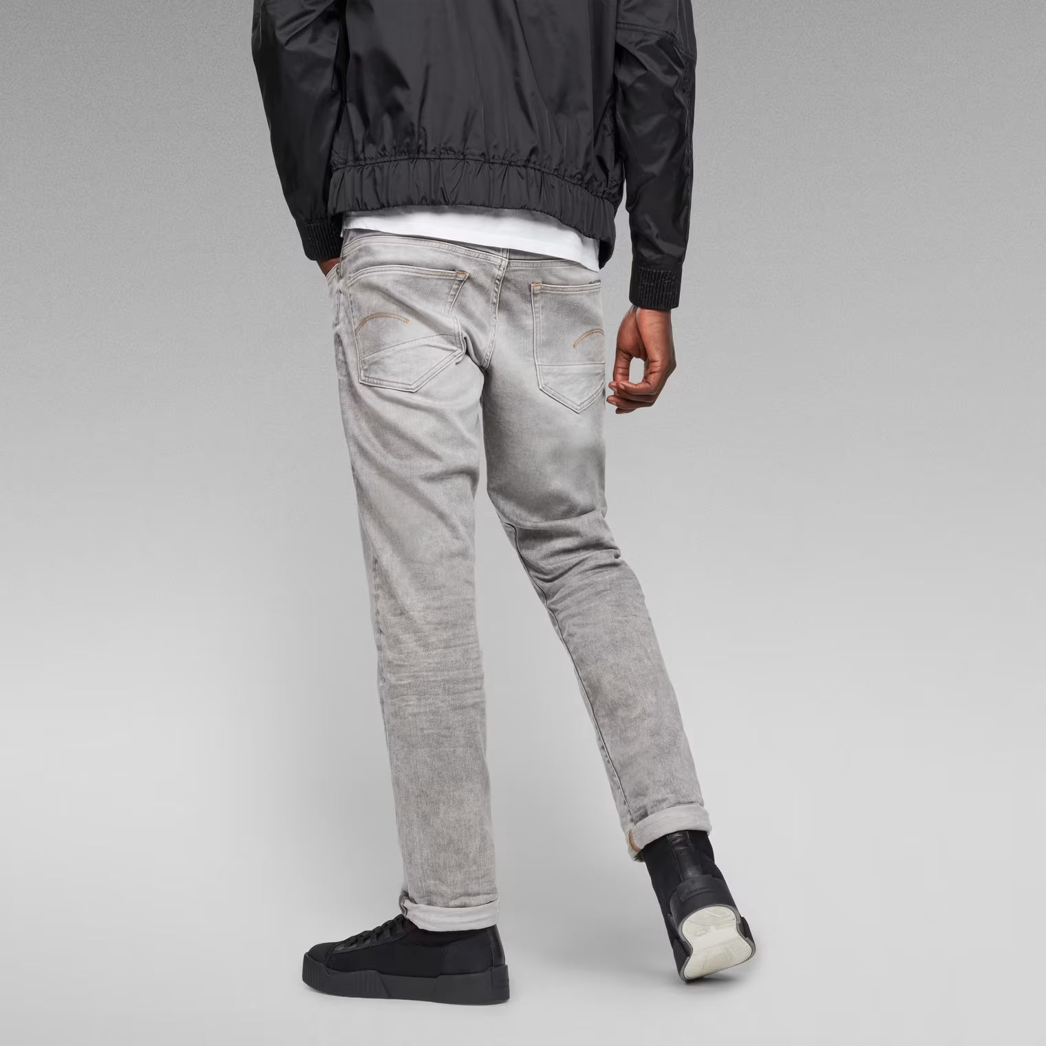 Back view of the grey tapered jeans showcasing the regular fit and five pockets.