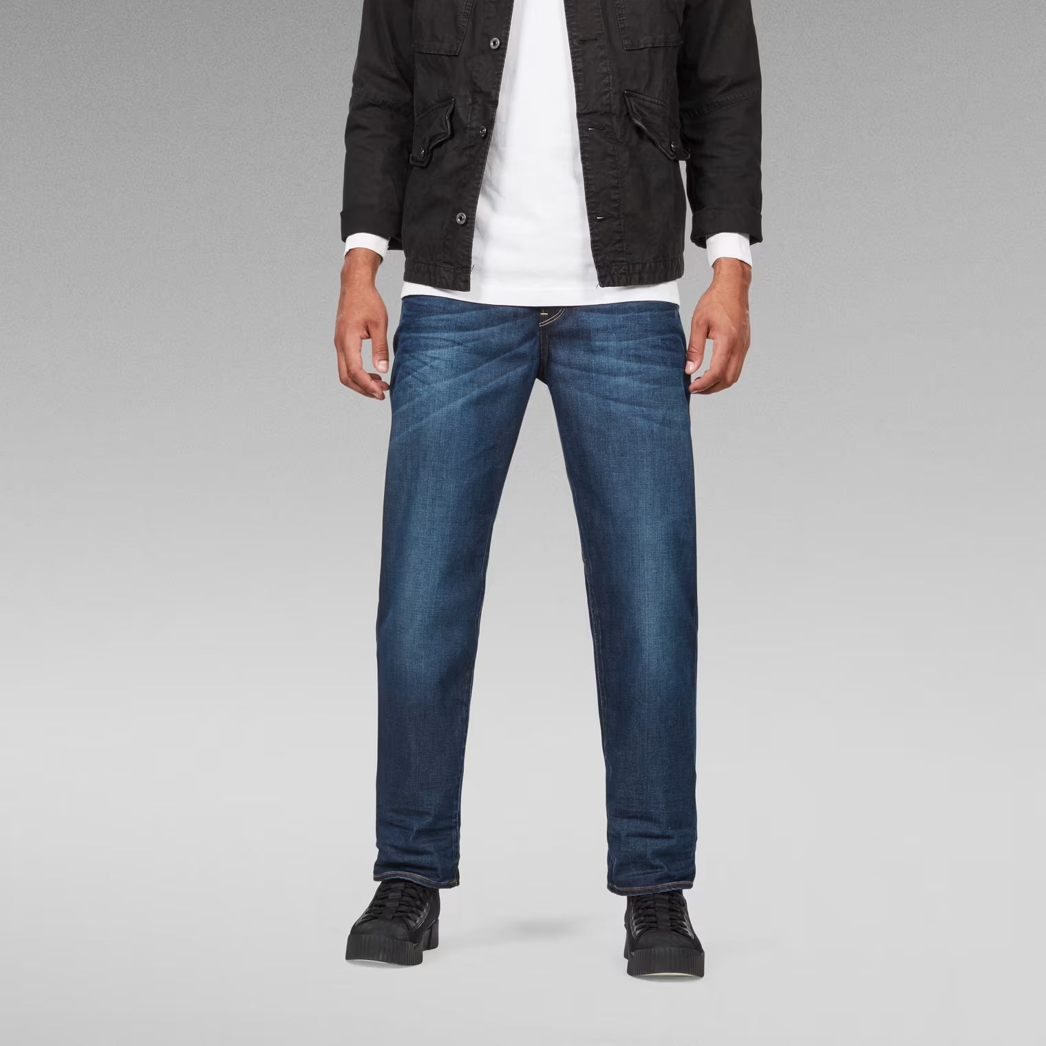 Lifestyle shot of dark blue relaxed fit jeans with a straight leg.