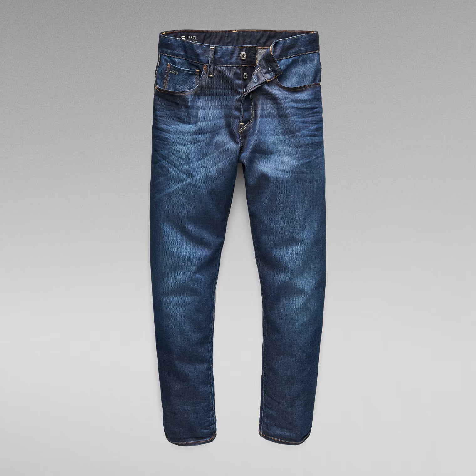 Front view of dark blue jeans featuring a zipper fly and belt loops.