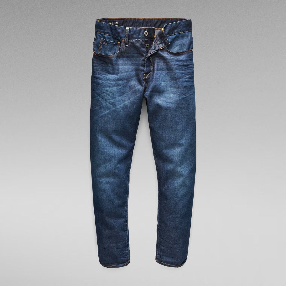 Front view of dark blue jeans featuring a zipper fly and belt loops.