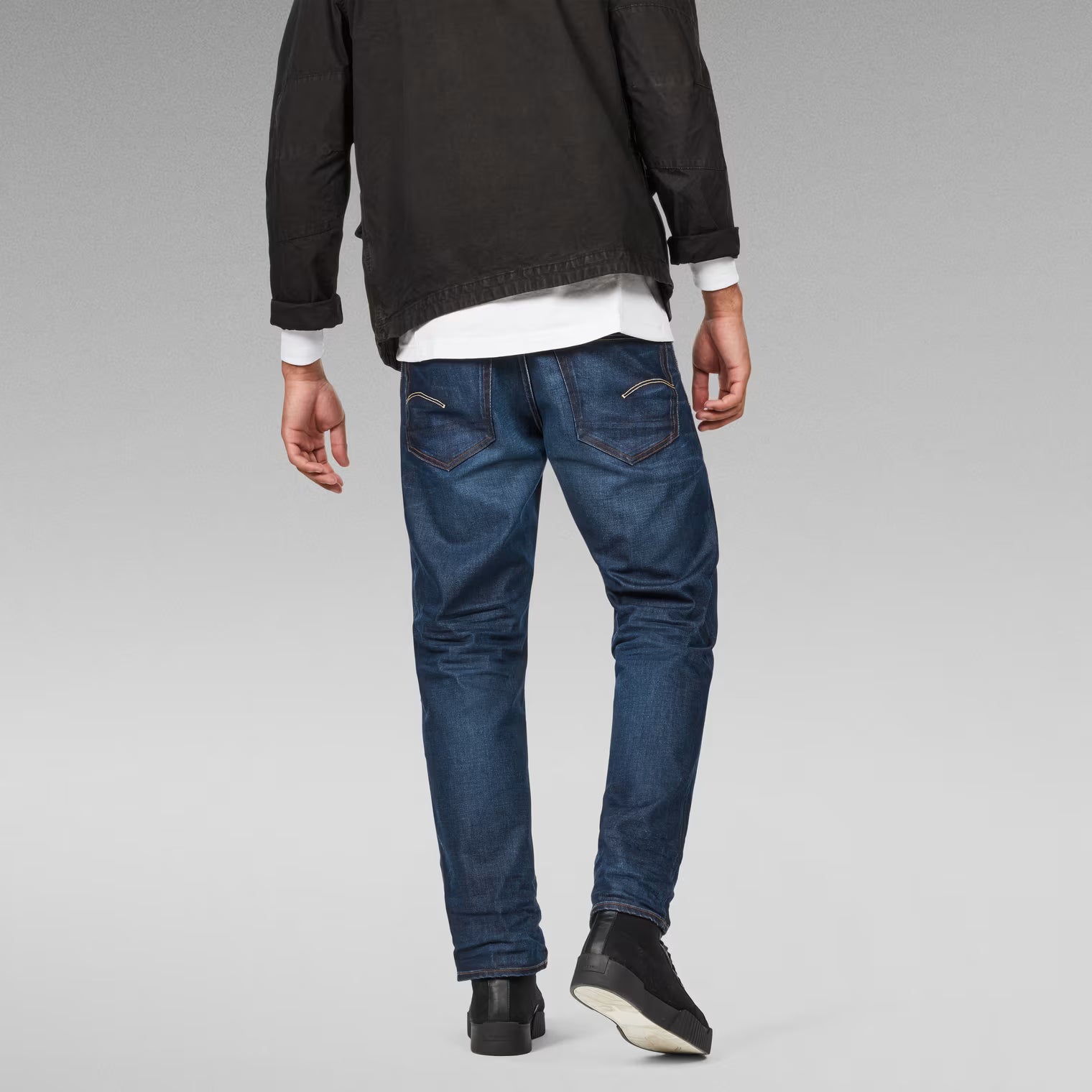 Back view of dark blue relaxed fit jeans showcasing the straight leg design.