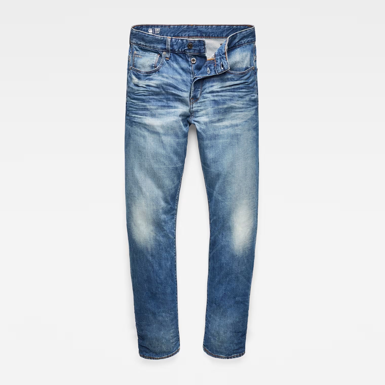 Front view of relaxed straight jeans in medium blue with distressed details and five pockets.