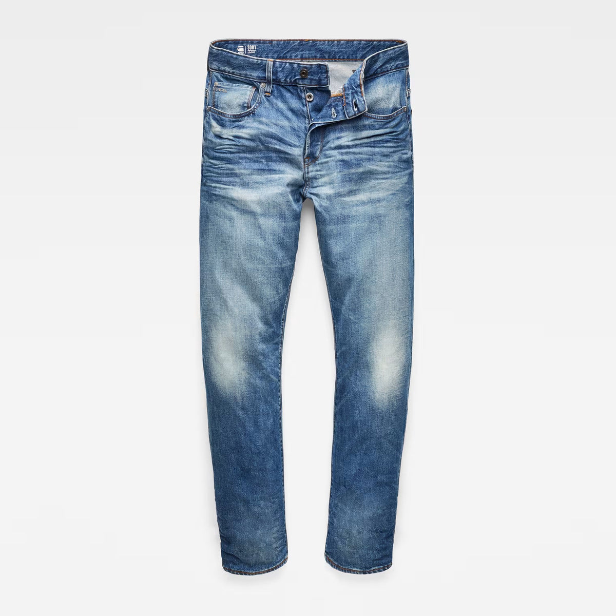 Front view of relaxed straight jeans in medium blue with distressed details and five pockets.