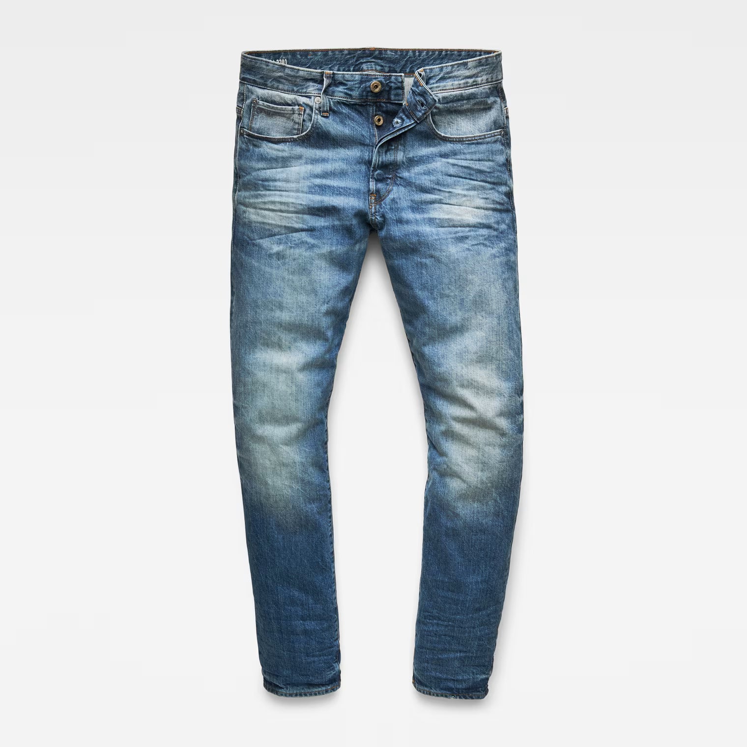 Front view of medium blue jeans with a straight tapered fit and distressed details displayed on a white background.