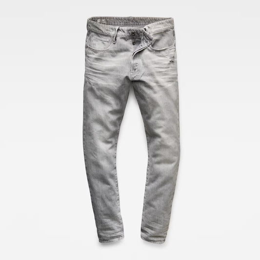 Front view of grey denim pants featuring a tapered fit and five pockets against a white background.