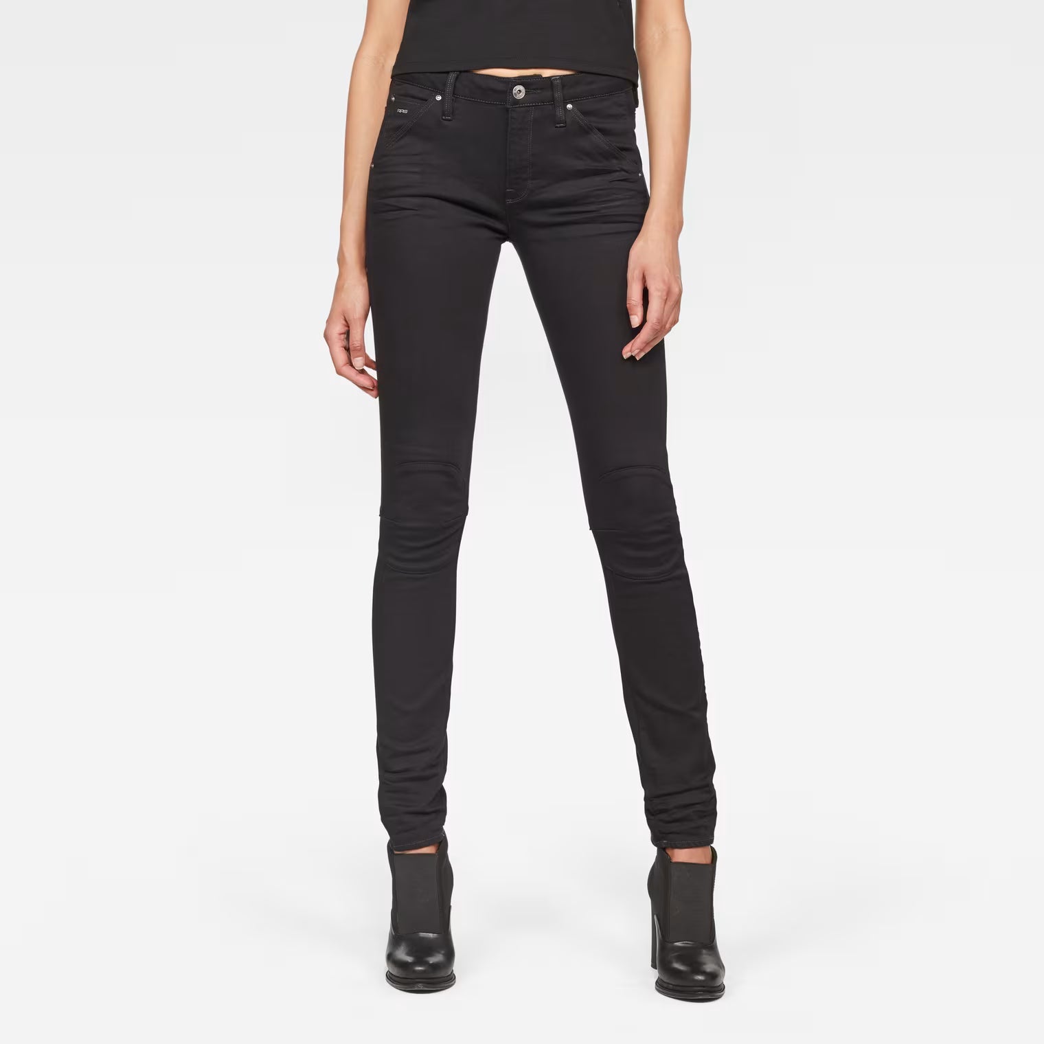 Front view of black skinny jeans with mid waist and skinny fit on a white background
