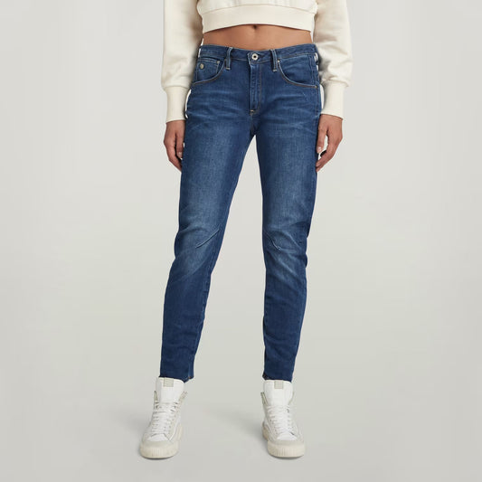 Lifestyle shot of dark blue boyfriend jeans featuring a low waist and slim fit.