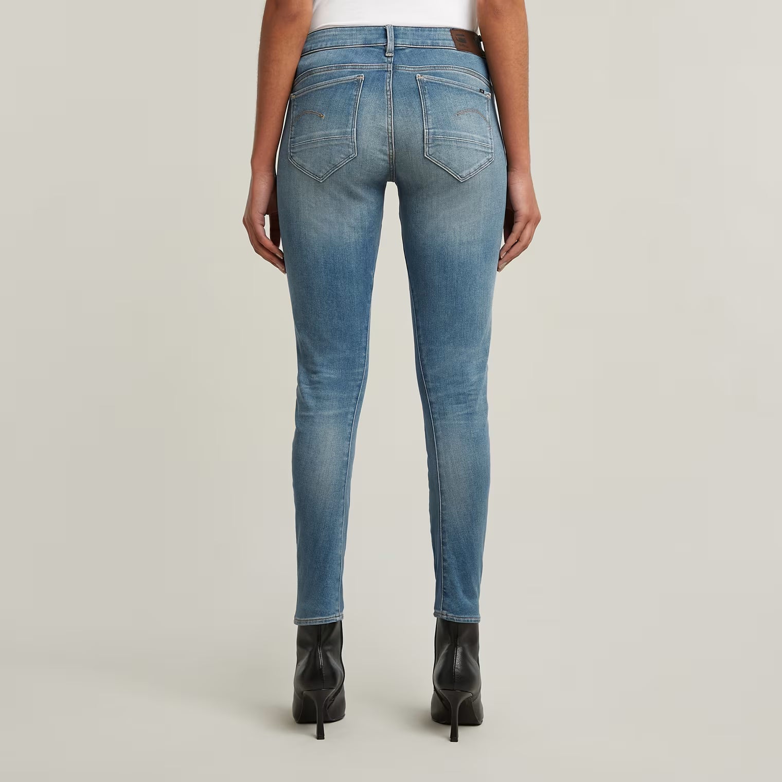 Back view of blue skinny jeans showcasing a faded design and slim fit.
