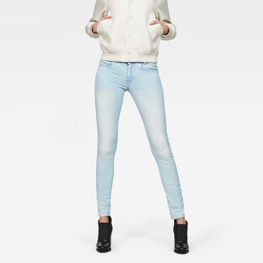 Lifestyle shot of light blue skinny jeans featuring a 5-pocket design against a white background.