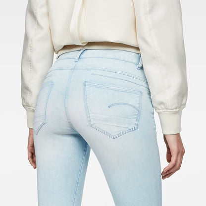 Detail close-up of light blue skinny jeans highlighting the 5-pocket design on a white background.